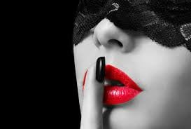Woman with red lips in lace eye mask, finger to lips for sensual wellness and self-care