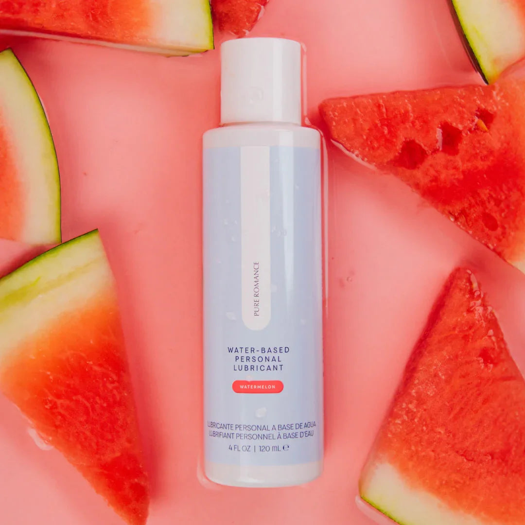Water-based personal lubricant bottle with watermelon slices on a pink background
