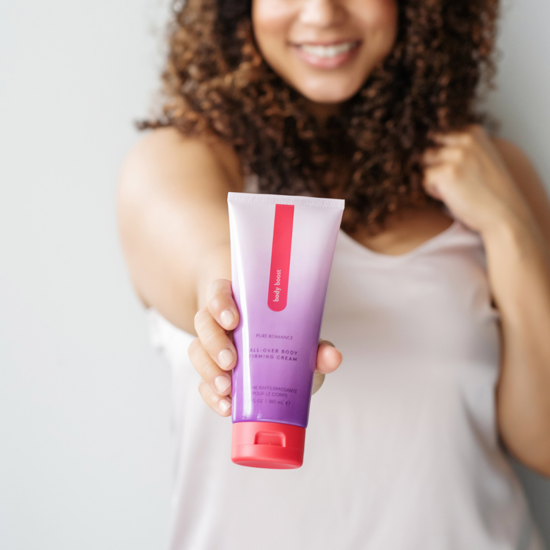 Woman holding tube of body firming cream for skincare