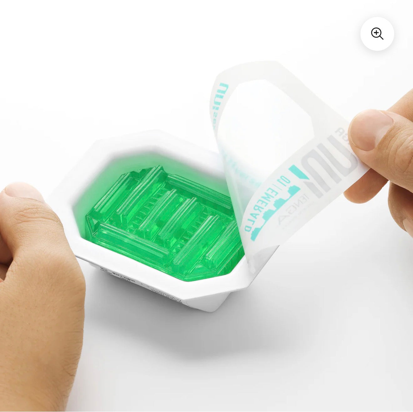 Hand opening package of green translucent soap bar, wellness and skincare product