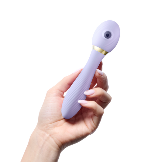 Hand holding purple silicone personal massager with gold accent for wellness and self-care