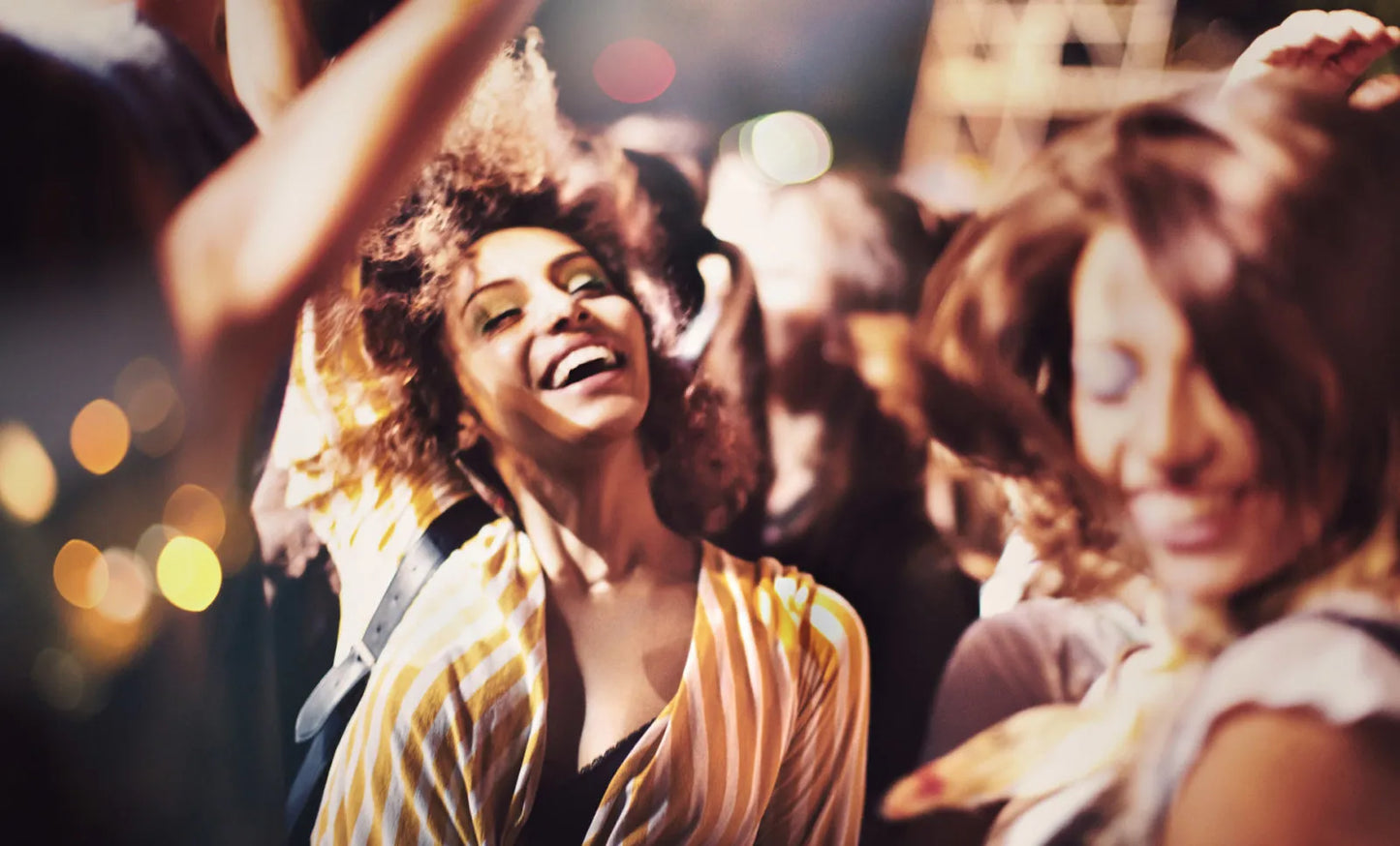 Women enjoying a lively bachelorette party, dancing and smiling in a vibrant celebration.