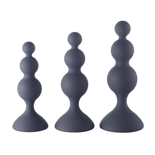 Set of three graduated black silicone beaded trainer plugs on a neutral background.