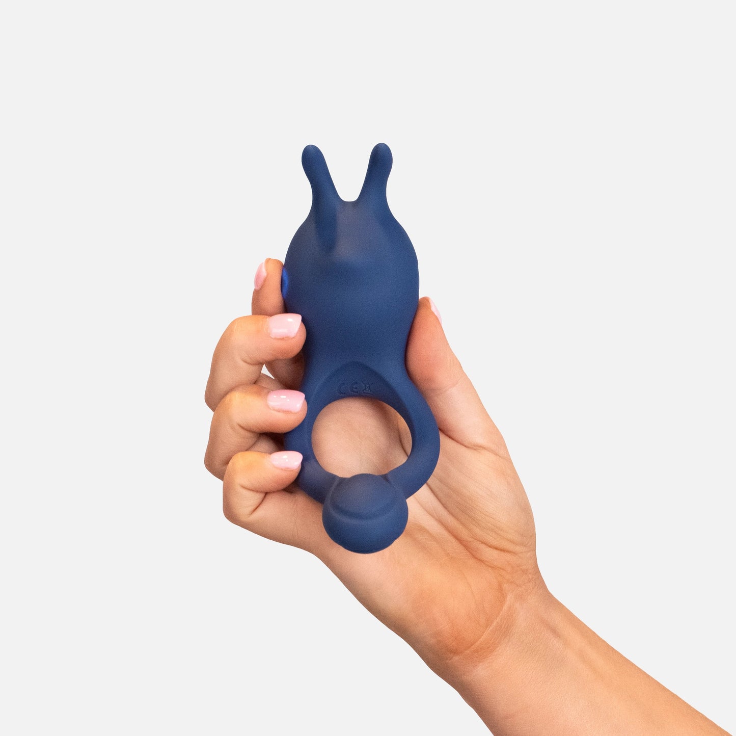 Hand holding a blue silicone couples vibrating ring against a white background