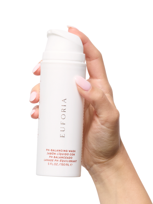 Hand holding Euforia pH-balancing wash bottle for skincare and wellness.
