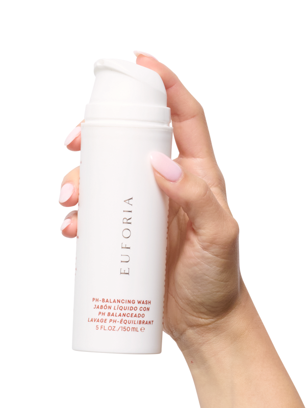 Hand holding Euforia pH-balancing liquid wash bottle, skincare product for gentle cleansing