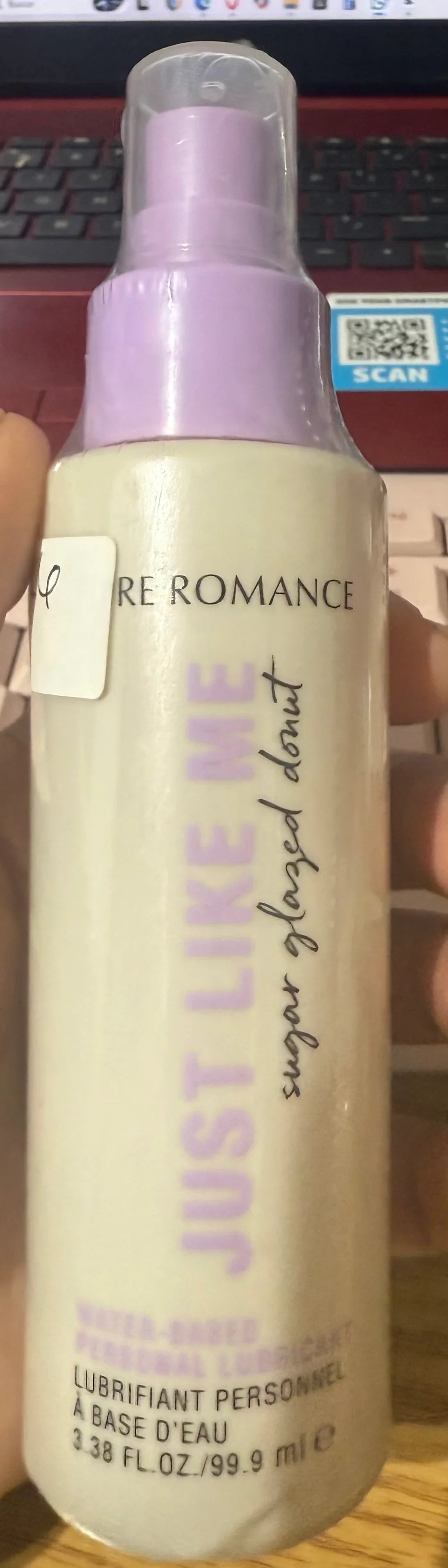 Water-based personal lubricant in a pump bottle, held in hand, purple and white packaging