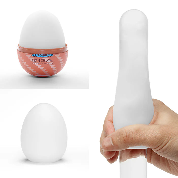 Textured silicone egg-shaped personal massager in white, shown with hand for scale.