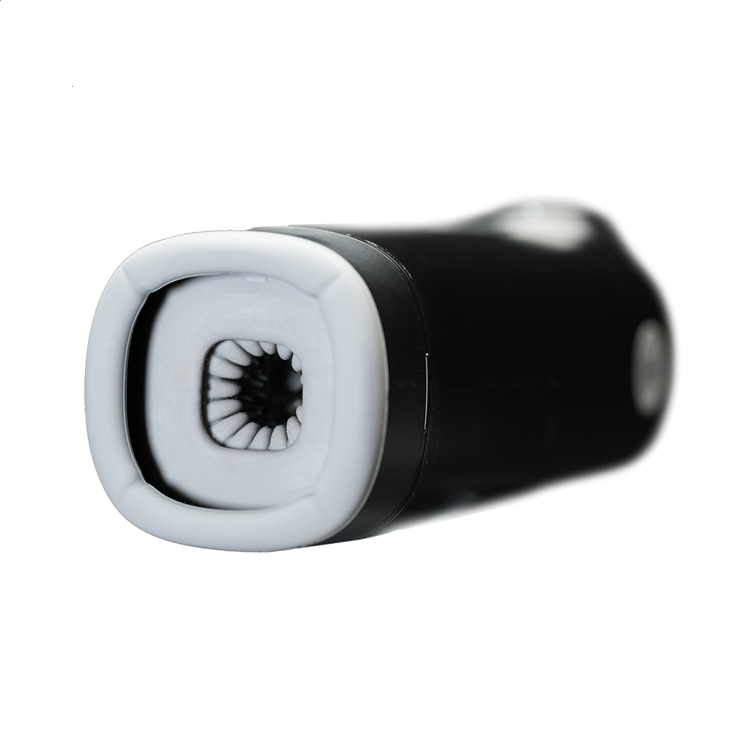 Close-up of a black and white personal wellness massager device against a dark background