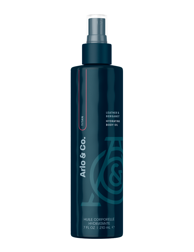 Dark blue bottle of leather and bergamot hydrating body oil with spray nozzle, 210ml