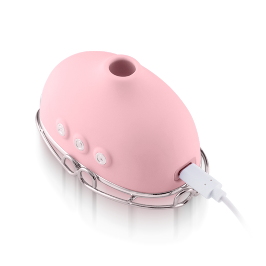 Pink silicone personal massager with buttons and USB charging cable on a metal stand