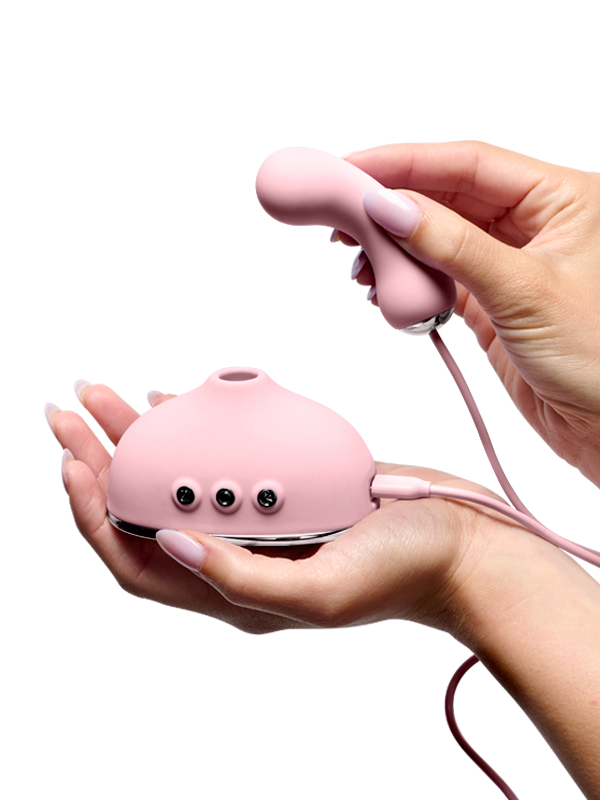 Pink silicone wellness massager with ergonomic design held in hands