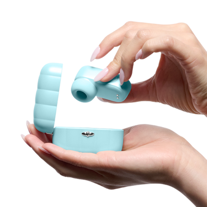 Hand holding blue wellness massager with open charging case for personal care