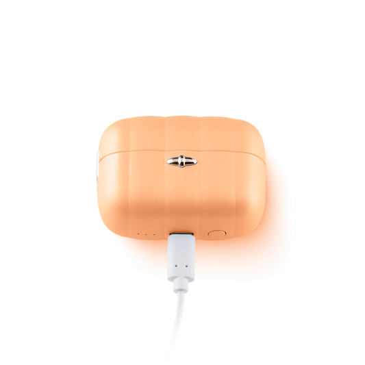 Orange silicone personal massager charging in case, wellness and self-care product