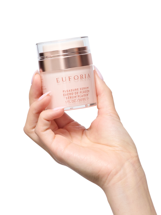 Hand holding Euforia pleasure serum skincare bottle, 30ml, on a white background