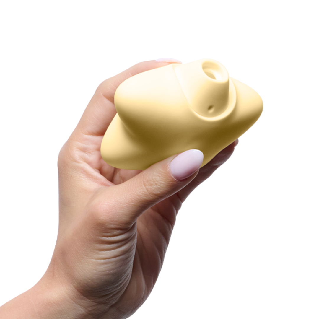 Hand holding a yellow silicone personal massager with ergonomic design