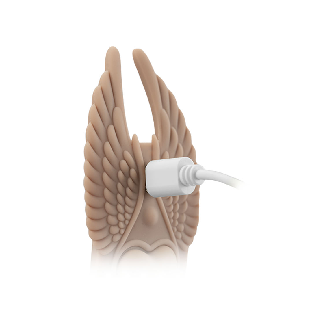 Silicone wing-shaped massager charging via USB cable, close-up view