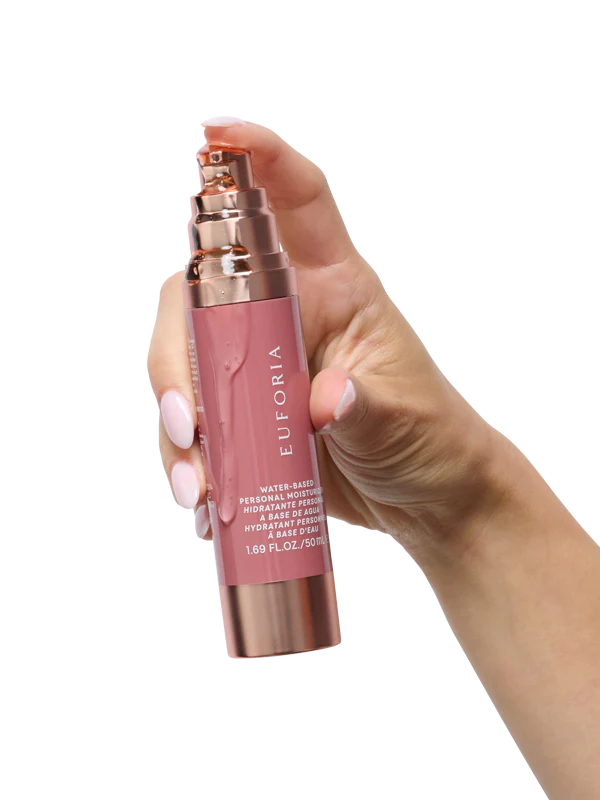 Hand holding Euforia water-based personal moisturizer bottle, rose gold and pink packaging