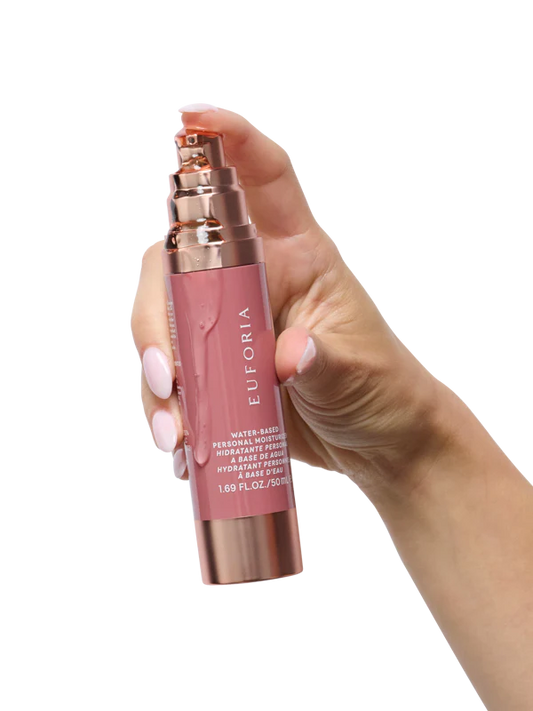 Hand holding Euforia water-based personal moisturizer bottle, rose gold and pink packaging