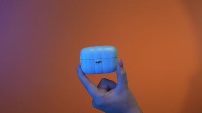 Hand holding a white, compact skincare or wellness product case against an orange background